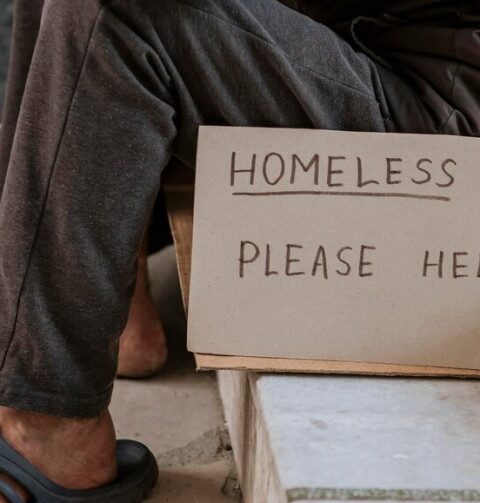 senza tetto con cartello "Homeless, please help"