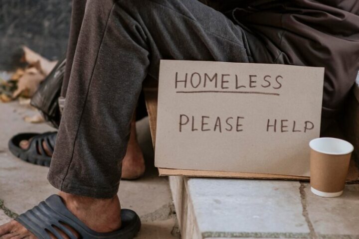 senza tetto con cartello "Homeless, please help"